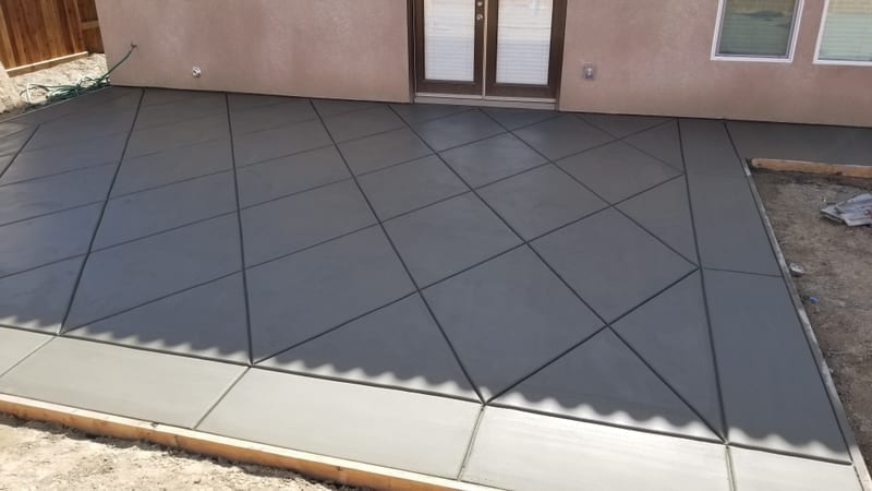 Decorative concrete patio with diamond saw-cut pattern in dark charcoal color