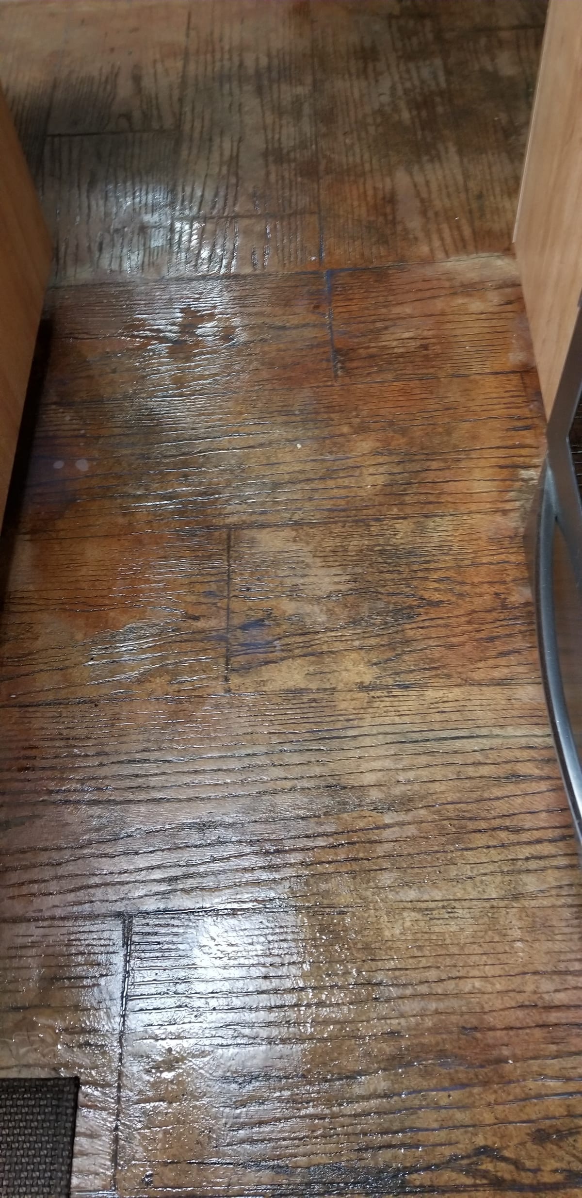 Close-up of wood-plank stamped concrete showing realistic wood grain texture in warm terracotta tones